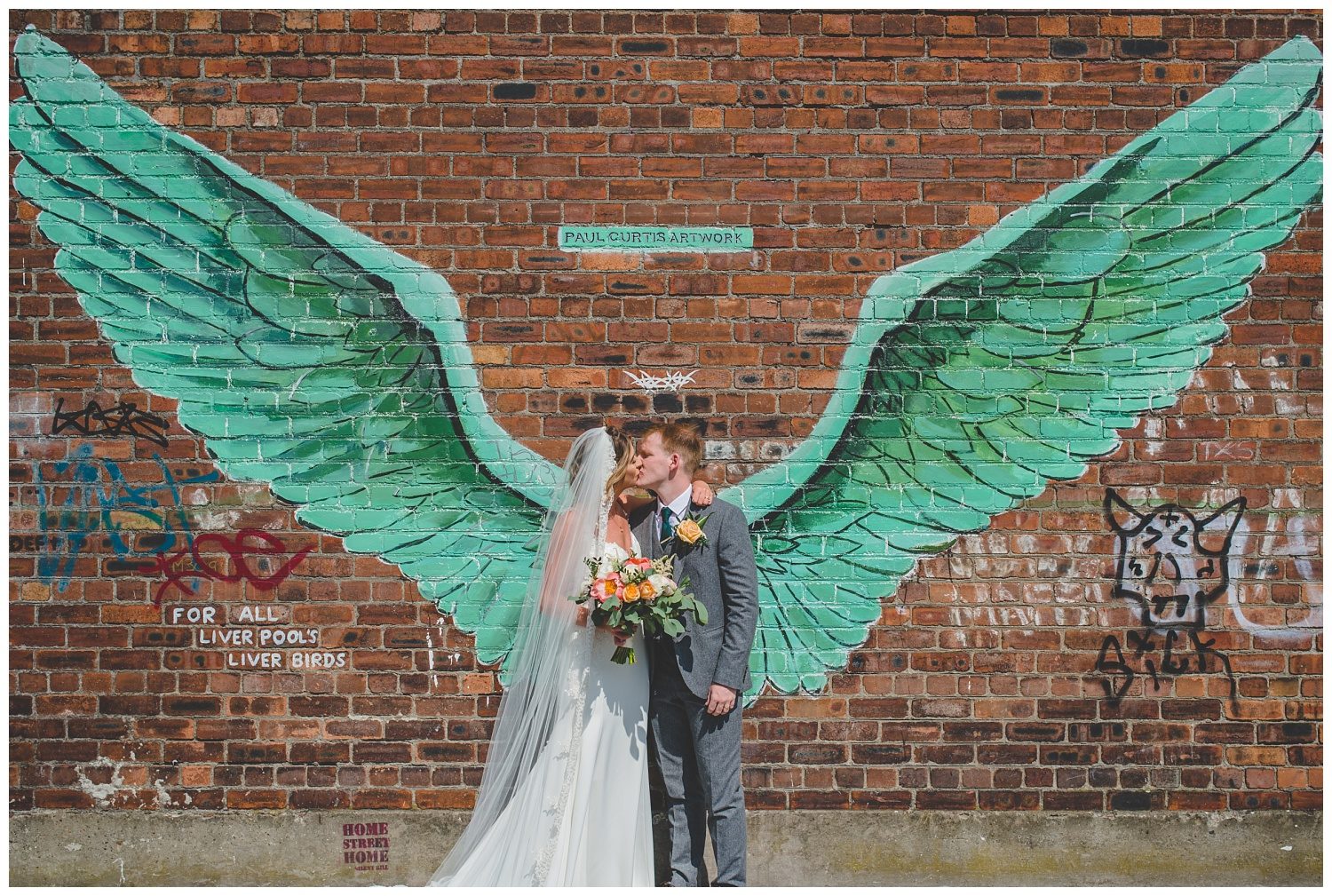 bride and groom with Paul Curtis wings